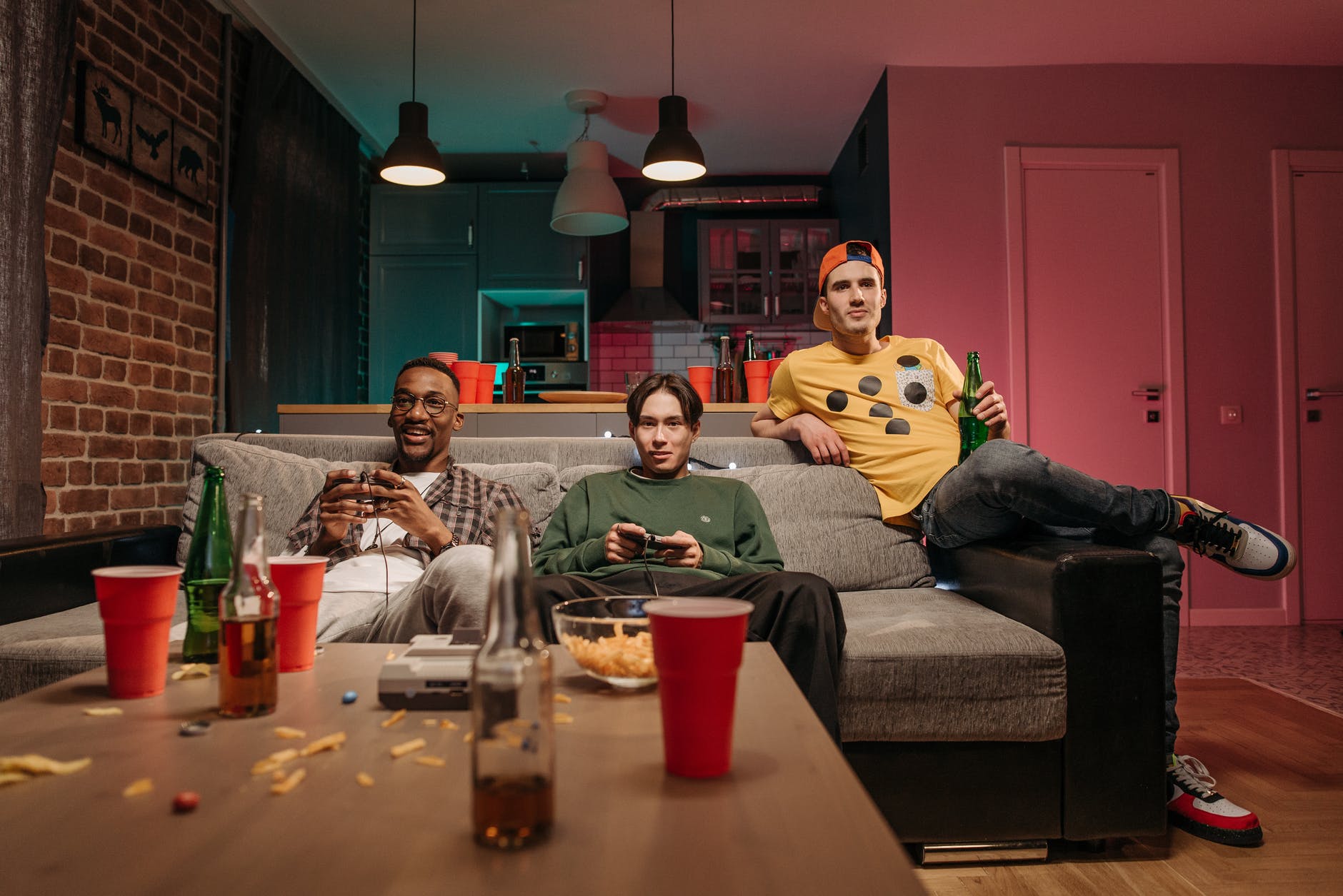 men sitting on a sofa while playing video games