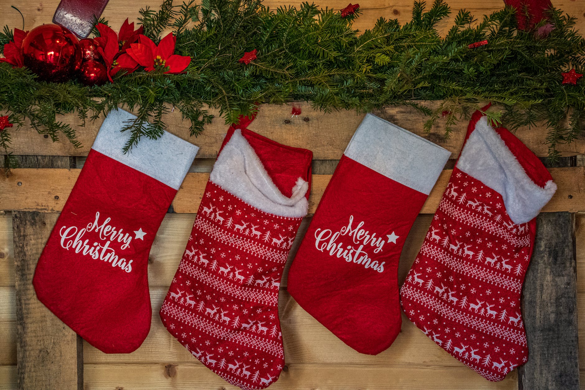 a row of christmas stockings hanging on wooden wall