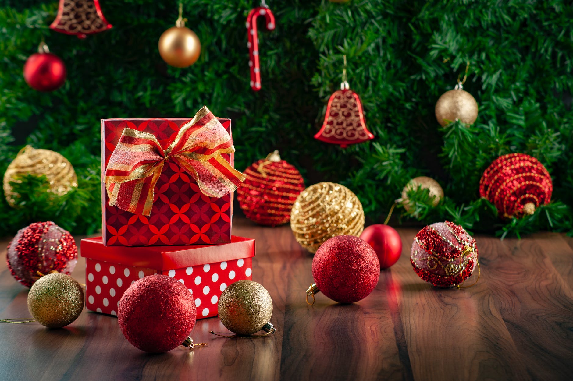 close up photo of christmas balls and presents on a wooden floor