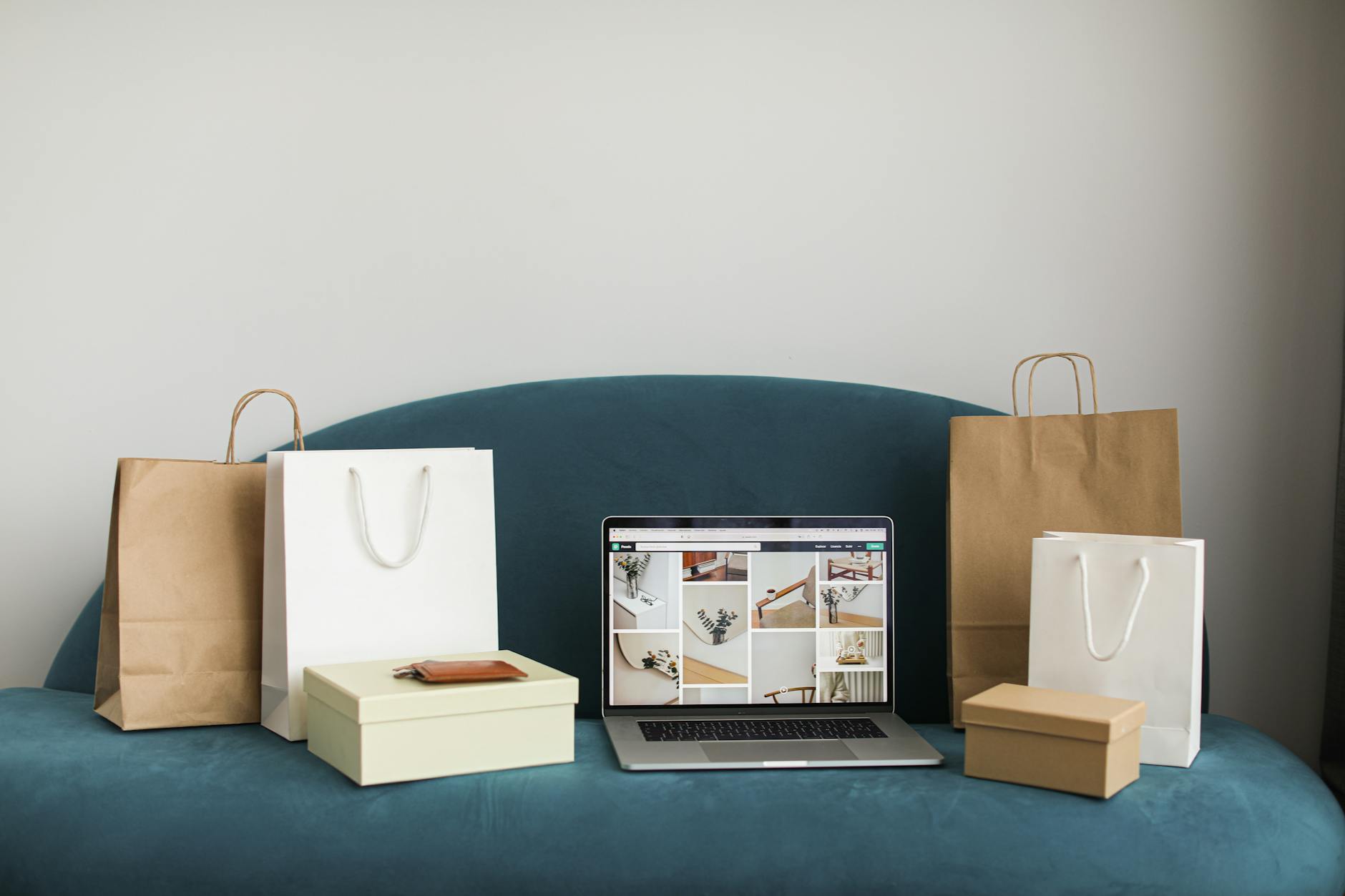 macbook pro with shopping bags and boxes on blue couch
